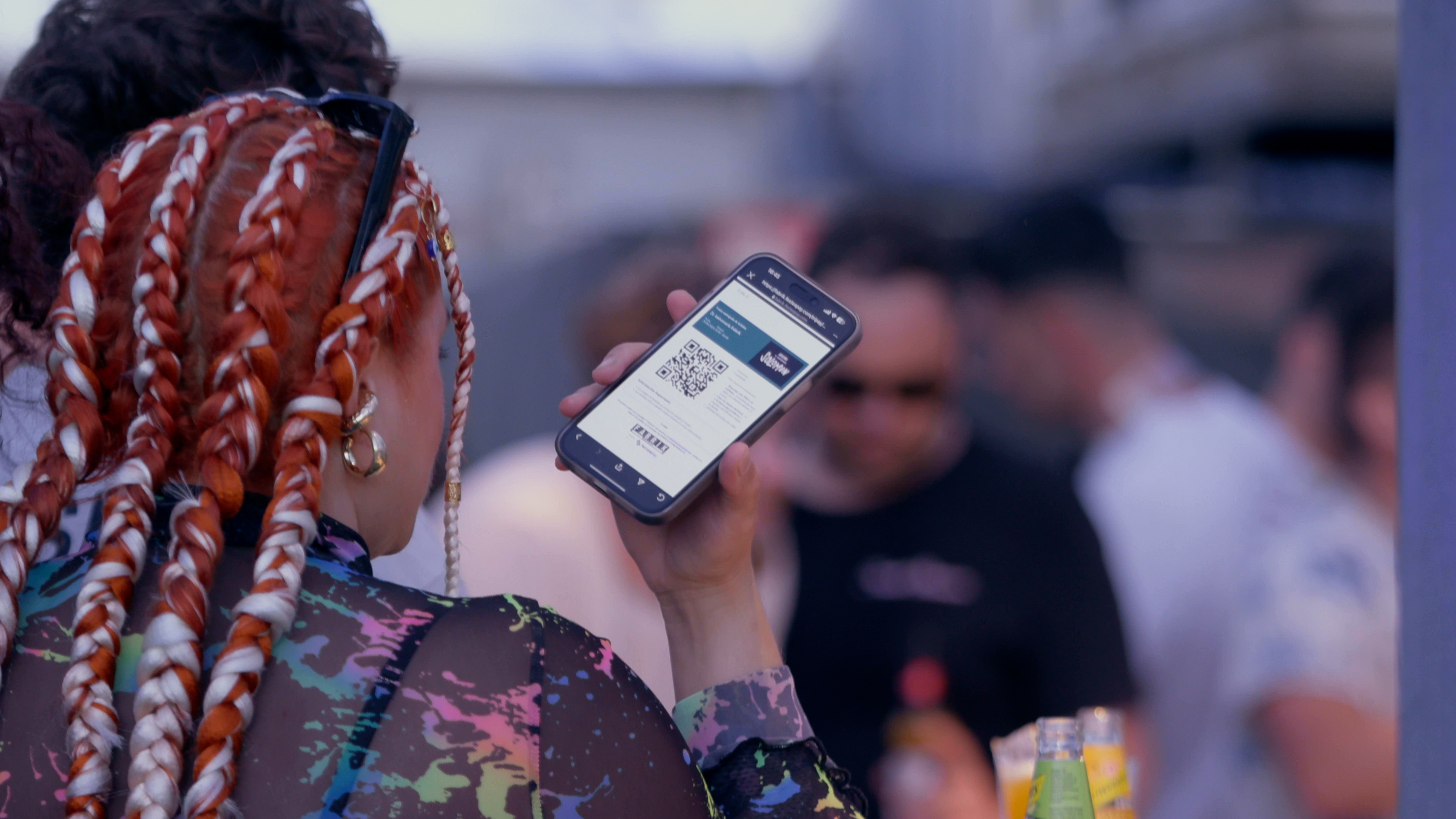 Una camarera escaneando ubn código QR en una barra