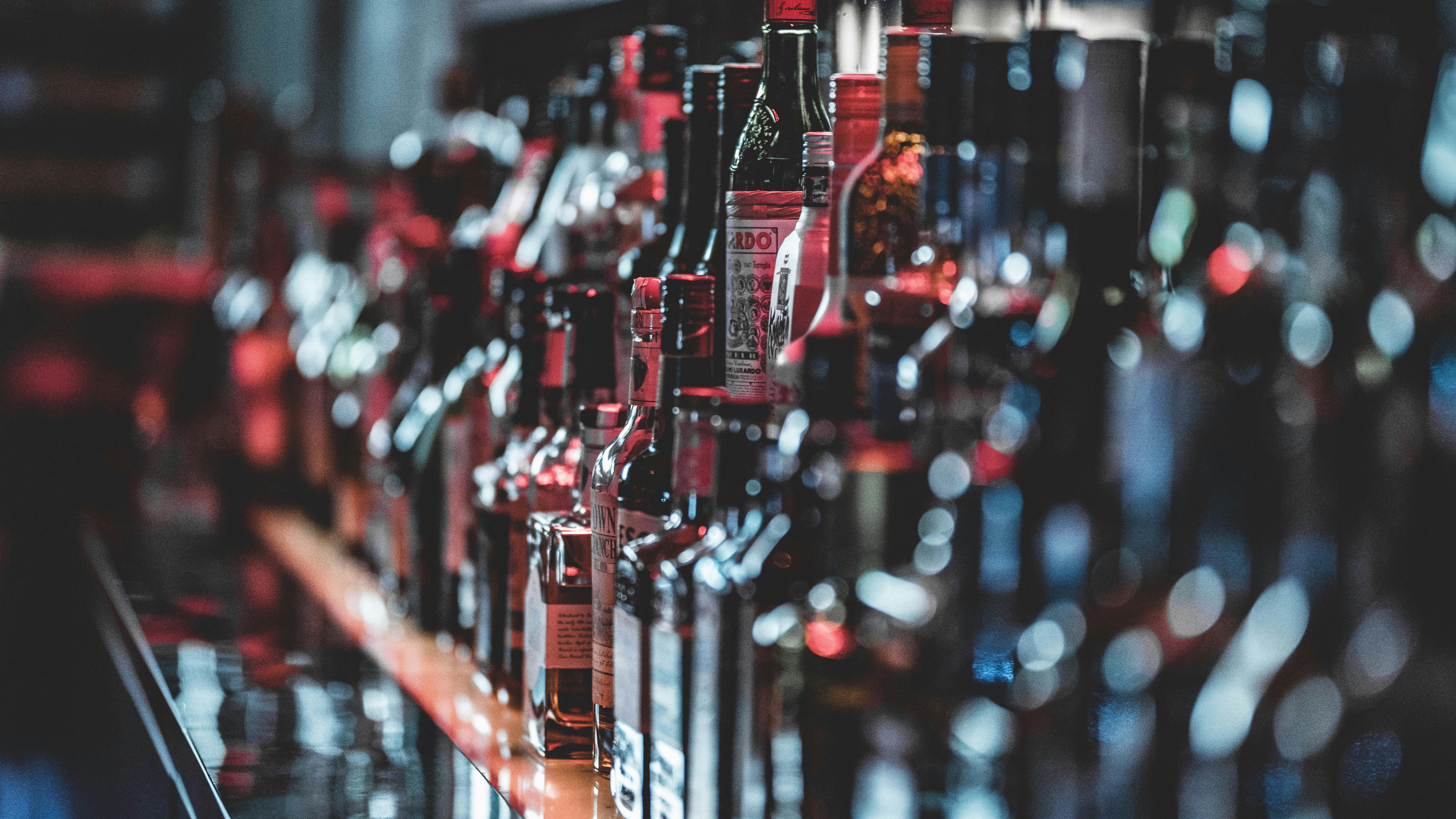 Una imagen decorativa de una barra con varias botellas en el fondo